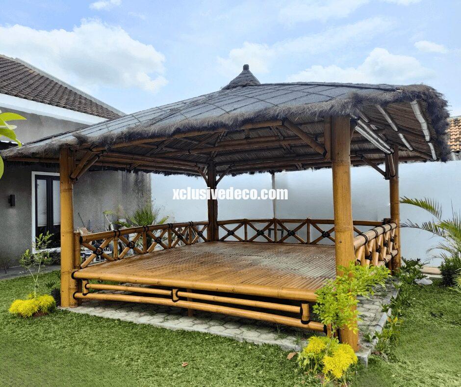 gazebo XL large avec toit en chaume dans un jardin au bord d'une piscine