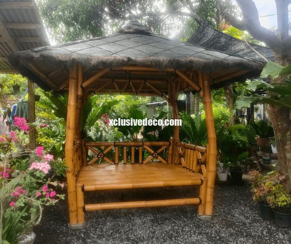 paillotte en bambou de bali installée dans jardin luxuriant exotique