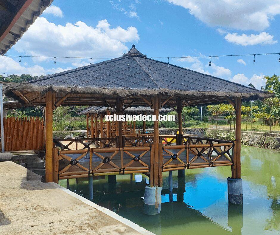 Gazebo paillotte en bambou sur pilotis au bord de l'eau, en bord de rivière